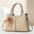 Elegant beige lychee texture leather handbag with silver handle and bear pendant - Khaki