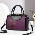 Dunkelviolette Tasche mit Krokodilprägung, schwarzem Lackbesatz und goldenen Details - Lila