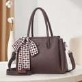 Elegant dark brown pebble grain handbag with decorative scarf on white stone surface - Coffee