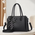 Classic black leather handbag with lychee pattern and polka dot scarf on a marble table - Black