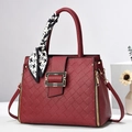 Burgundy quilted handbag with houndstooth scarf handle and golden hardware on white stand - Wine Red