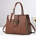 Sac à main chic marron caramel avec foulard et boucle dorée en studio professionnel - Café