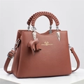 Detail view of caramel brown lychee leather handbag with woven handles and gold logo - 26x12x20cm / Earthy Yellow