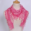 Détail d'un châle triangulaire en dentelle rose avec broderies florales et pompons - Rose rouge