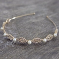 Vista macro de la diadema dorada con perlas y pedrería en diseños de hojas de novia - Diamante de Imitación Perla Dorado