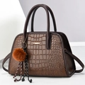 Detailed close-up of dark brown crocodile pattern leather handbag with gold metal accents - Medium / Coffee