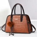Brown crocodile pattern handbag with gold clasp and plush charm on white background - Medium / Earthy Yellow