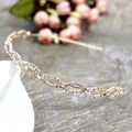 Dettaglio del cerchietto in metallo dorato con design a onde intrecciate e strass lucidi - Oro Pieno di Strass (C8205)