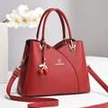 Red pebbled leather crossbody handbag with top handles and cherry charm accessory - Burgundy