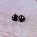 Macro detail of 8mm round black zircon earrings with gold-plated four-prong setting - Gold + Black