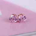 Macro view of 8mm pink zircon stud earrings with gold six-prong setting detail - Gold+Pink