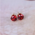 Close-up of red zircon stud earrings with classic gold-plated six-claw setting - Gold + Red