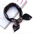 Elegant black silk square scarf featuring vibrant paisley print patterns tied in a soft knot - Sunflower Black
