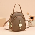 Three-layer dark brown leather mini backpack featuring a golden cat charm and lychee texture - Brown