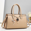Dettaglio borsa a tracolla beige martellata con ciondoli a perla e a gatto - 30x13x20cm / Cachi
