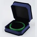 Emerald green jade bangle displayed in a navy blue octagonal velvet jewelry gift box - Bracelet Box / Blue With Black Interior