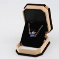 Octagon velvet jewelry box featuring a golden necklace with a blue clover pendant - Small Pendant Box / Yellow With Black Interior