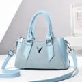 Bolso tipo almohada tejido azul con logo V plateado y correa de hombro ajustable - Azul