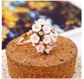 Detailopname van gouden boeketring met roze bloemblaadjes en glinsterende strass - Oorbellen / Wit