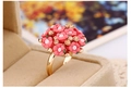 Détail de la bague dorée ornée de fleurs roses et cristaux dans un écrin en velours - Rose Foncé