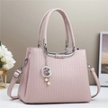 Detail of light pink handbag featuring vertical embossing and silver star moon charm - Pink
