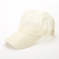 Detailansicht des atmungsaktiven floralen Spitzenmusters auf beige Baseballkappe - Beige