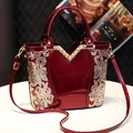 Elegant red patent leather handbag with floral embroidery and golden hardware accents - Burgundy