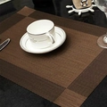 Bruine geweven PVC placemat met een witte theekop en bestek op een donker tafelblad - Diagonale Stijl / koffiekleur