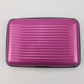 Top view of magenta aluminum card holder with ribbed texture and black protective edges - Rose Red