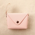 Close-up of pink macaron coin purse with bronze buckle on woven fabric background - Light Pink