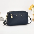 Dettaglio della pelle blu navy e della cerniera dorata sulla borsa a tracolla a righe - Blu
