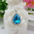 Elegant silver necklace with a pear-shaped blue crystal pendant on white roses - Single Necklace / Aqua