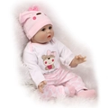 Realistic reborn baby doll in pink bear onesie and hat on white plush background - Rooted Hair / 55 cm