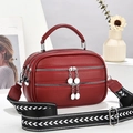 Fashionable burgundy leather handbag with woven wide shoulder strap and silver zippers - Burgundy