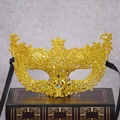 Masque vénitien à paillettes dorées avec motifs découpés sur un livre ancien - Doré