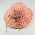Pink raffia sun hat with wide brim and brown leather bow ribbon for summer beach trips - Pink