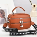 Brown lychee leather crossbody bag with three zippers and patterned woven strap - Earthy Yellow