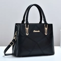 Detalle del bolso negro acolchado con logo dorado y textura de las costuras - Negro
