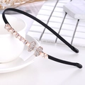 Detailed close-up of a black headband with shimmering rhinestones and a pearl bow design - Pearl Bowtie Style