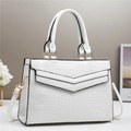 Borsa bianca con trama a coccodrillo, doppi manici e dettagli dorati su scrivania chic - Bianco
