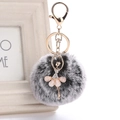 Detail of a ballet dancer pendant with a fluffy faux fur pompom on a gold keychain - 8cm Faux Rex Rabbit Fur / Black Snowflake/Star