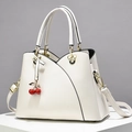 White faux leather tote bag with cherry charm and Mickey-shaped metal hardware details - White