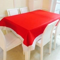 Détail d'un ensemble nappe de Noël rectangulaire rouge et blanche sur une table - Nappe