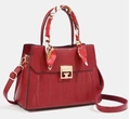Detalle de bolso de mano en cuero PU rojo con textura y pañuelo floral envuelto en el asa - Rojo