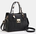 Detalle de bolso negro de piel con cierre metálico dorado y pañuelo de seda decorativo - Negro