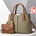 Close-up of brown printed leather tote bag set with golden hardware and round handles - Khaki