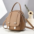 Detail view of khaki pebbled leather crossbody bag with dual zippers and metal trim - Khaki