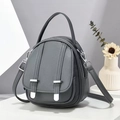 Detailed close-up of grey litchi texture leather handbag with silver metal buckles and straps - Dark Gray