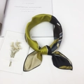 Moss green and black abstract silk scarf styled in a knotted loop on a white desk - Geometric Green