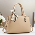 Detail of beige litchi grain faux leather handbag with golden hardware and silk scarf decor - Khaki